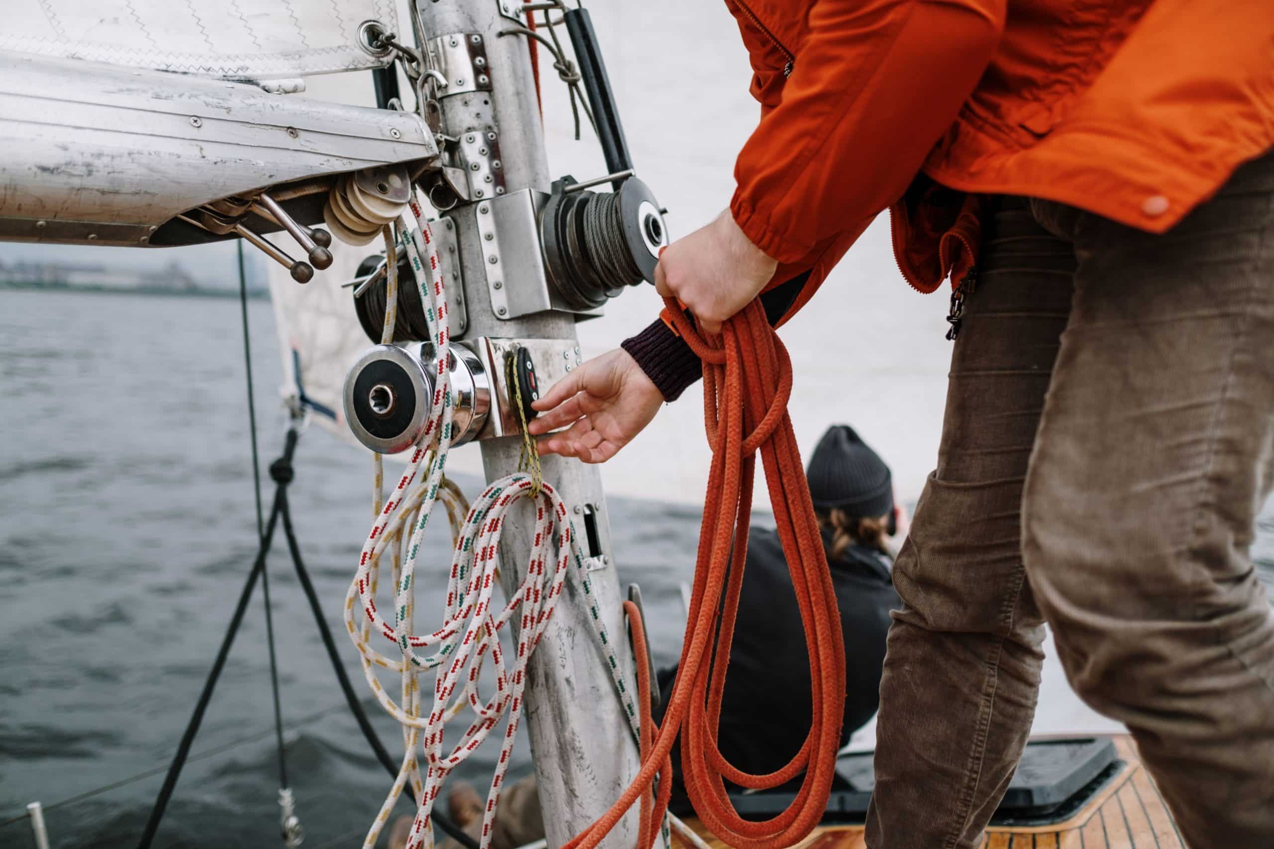 Person handling sailing ropes on a yacht.