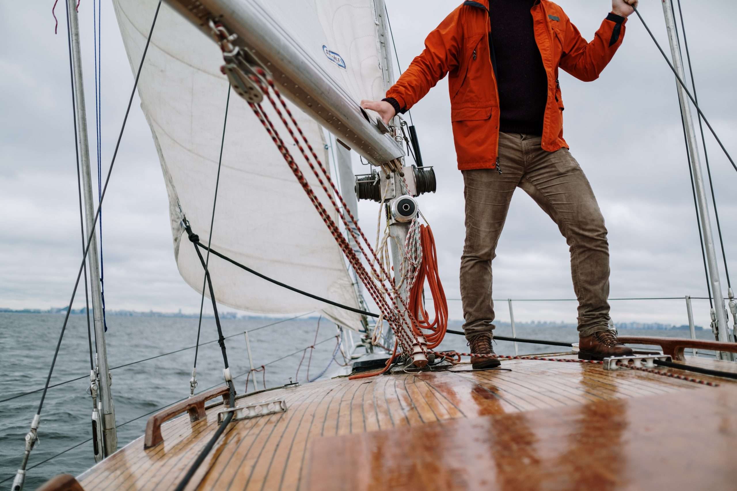Sailor standing on a yacht deck under sail